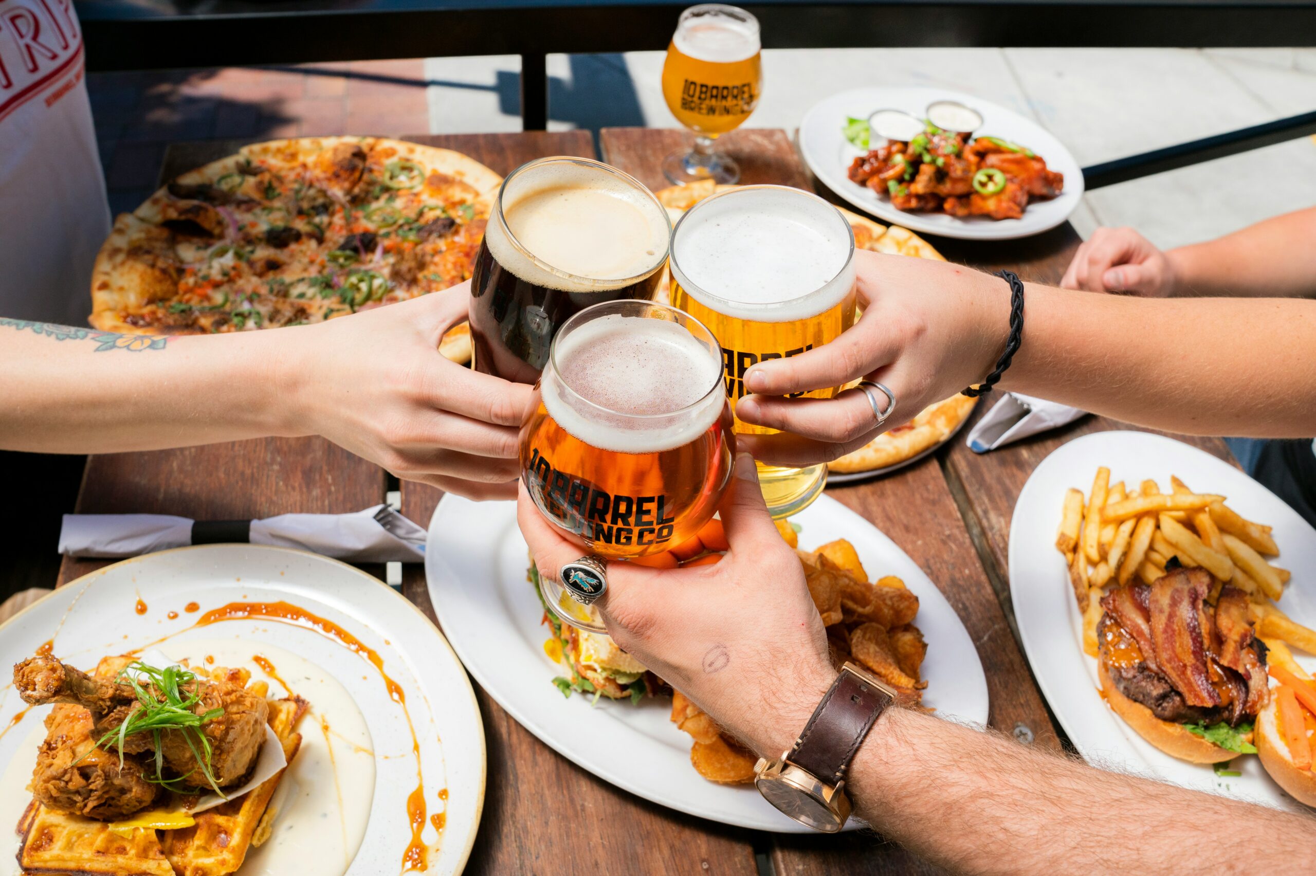 Sulla terrazza di un ristorante, gli amici brindano prima di iniziare a consumare i loro pasti