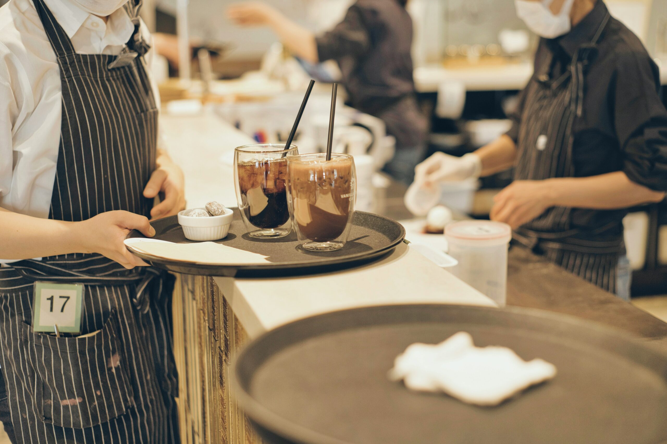 In a restaurant, a waiter carries a tray and brings an order to the table.