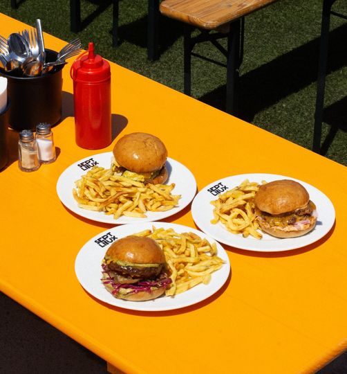 Foto di piatti soleggiati dell'area ristorazione Sept Lieux di Versailles, hamburger con patatine fritte