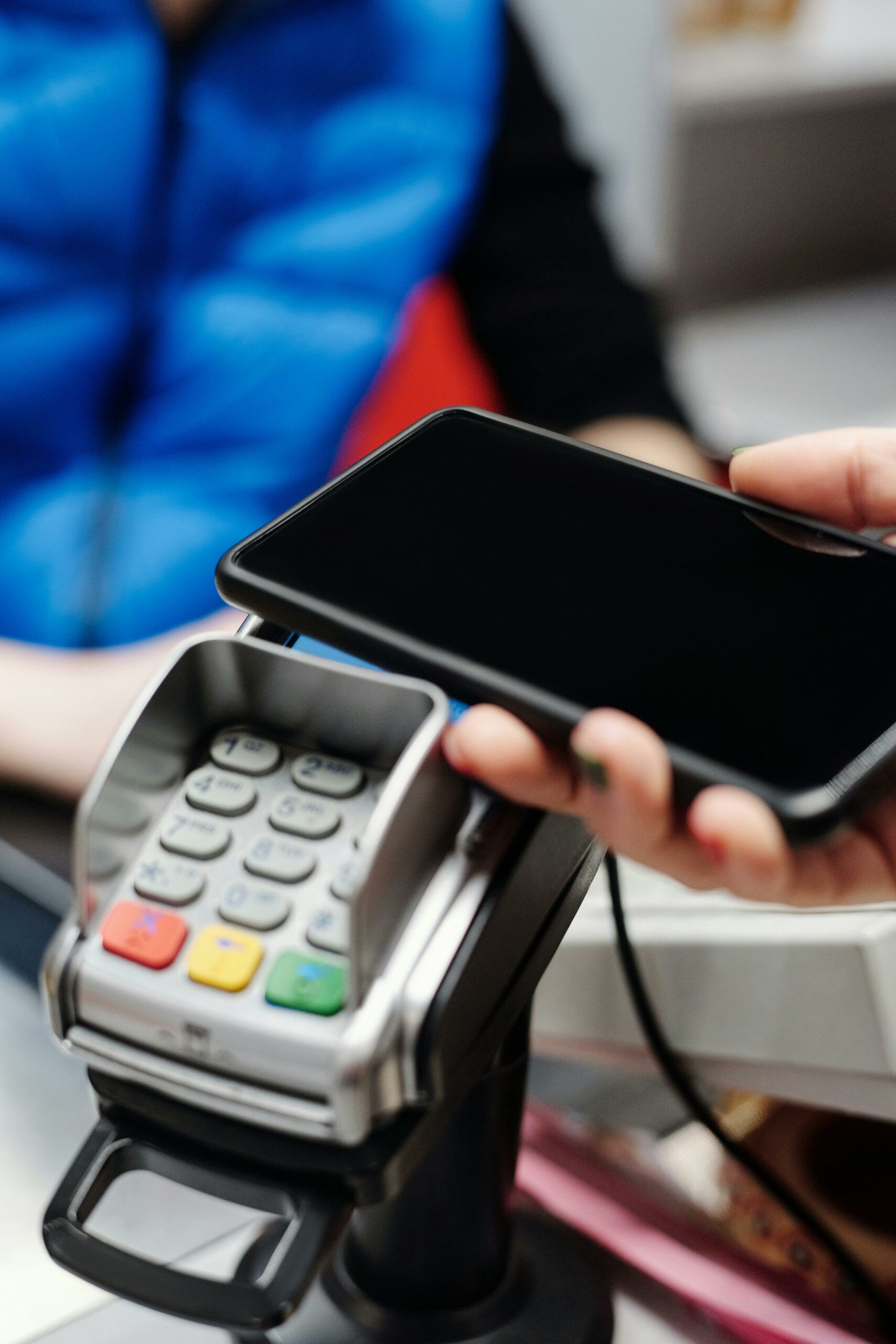 Un téléphone est approché d’un terminal de paiement pour régler en caisse.