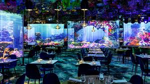 La photo montre une salle de restaurant immersive, décorée avec des projections marines.